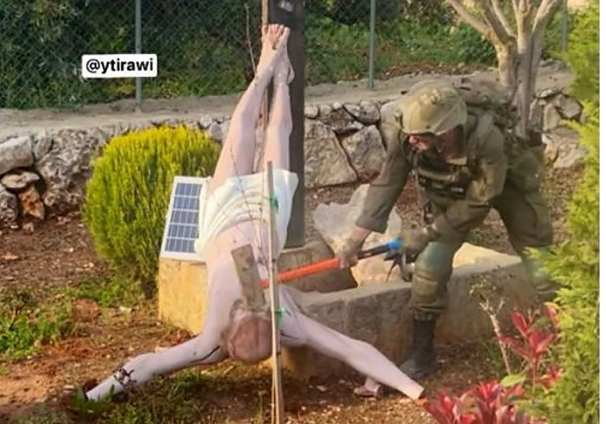 Un soldado israelí derriba a mazazos una estatua de Jesús en Líbano